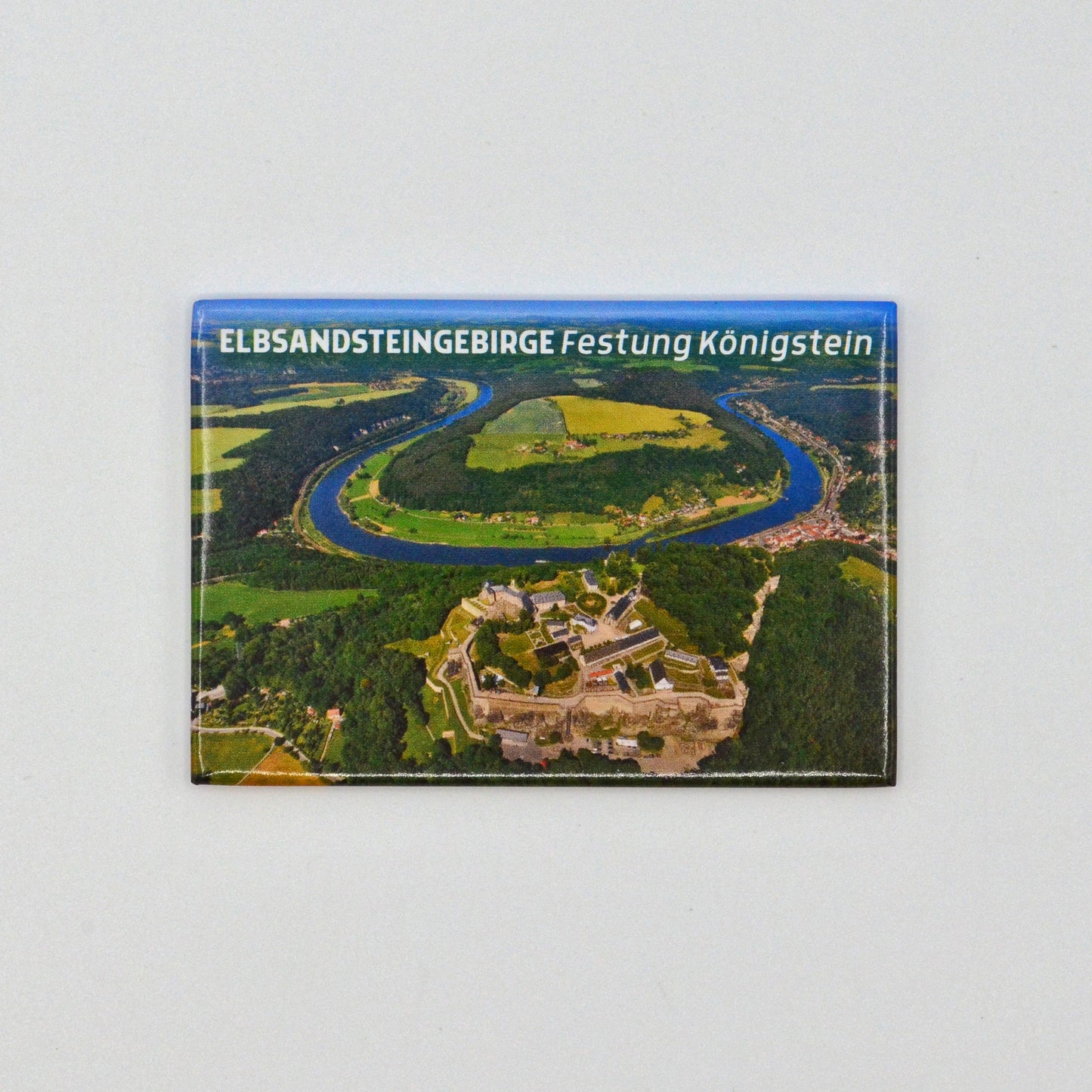 Luftbild Elbsandsteingebirge, Elbschleife und Festung Königstein im Vordergrund, weiße Schrift: Elbsandsteingebirge Festung Königstein