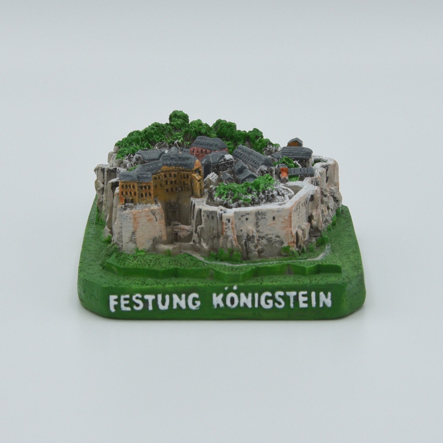 Modell Festung Königstein, West-Ansicht, grüner Sockel mit weißer Schrift: Festung Königstein, Festung in verschiedenen Grau- und Brauntönen