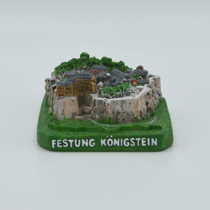 Modell Festung Königstein, West-Ansicht, grüner Sockel mit weißer Schrift: Festung Königstein, Festung in verschiedenen Grau- und Brauntönen