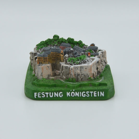 Modell Festung Königstein, West-Ansicht, grüner Sockel mit weißer Schrift: Festung Königstein, Festung in verschiedenen Grau- und Brauntönen