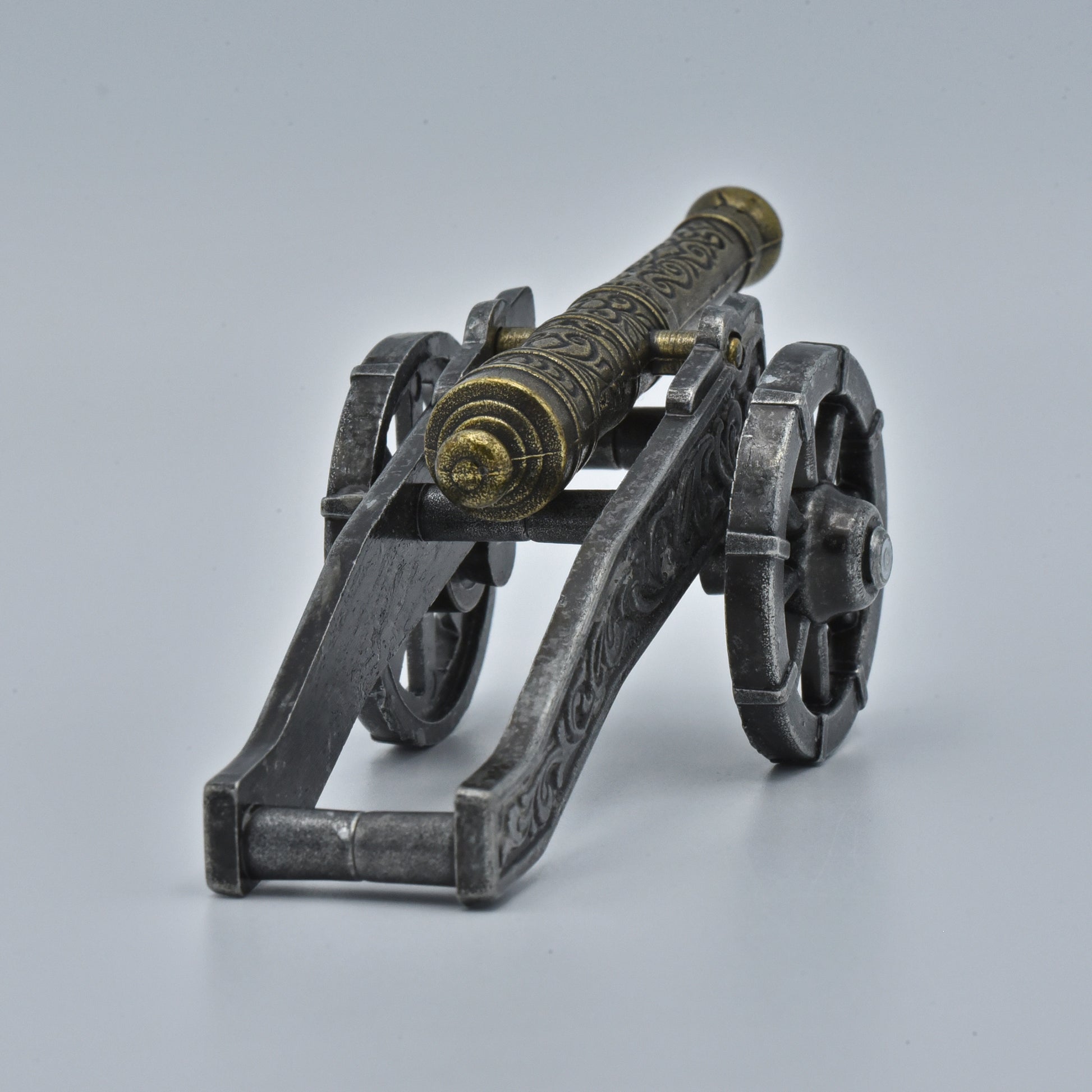 historische Kanone, reich verzierter goldener Lauf auf silbernem Stützarm zwischen den großen Rädern, Sicht von hinten 