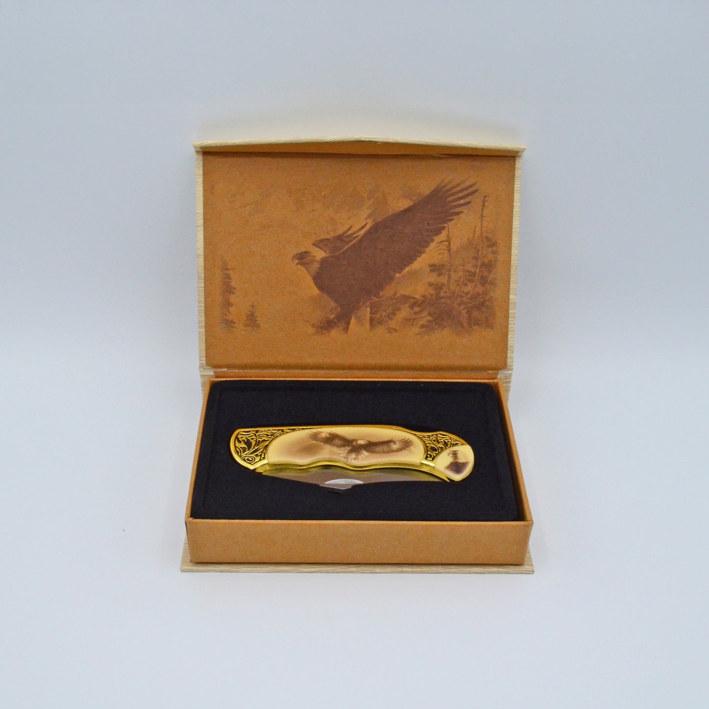 geöffnete helle Geschenkbox mit Adler im Deckel, darin Klappmesser, heller Griff mit Adler und Verzierungen