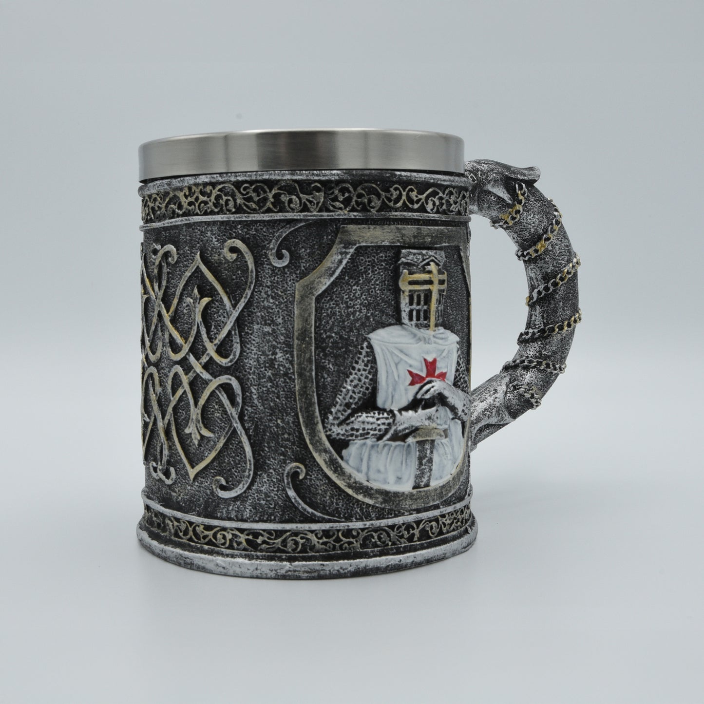 reich verzierter Humpen, silbergrau weiß, reliefartig gearbeiteter Kreuzritter stehend auf Schwert gestützt, in sich verschlungene Ornamente, mit Edelstahleinsatz