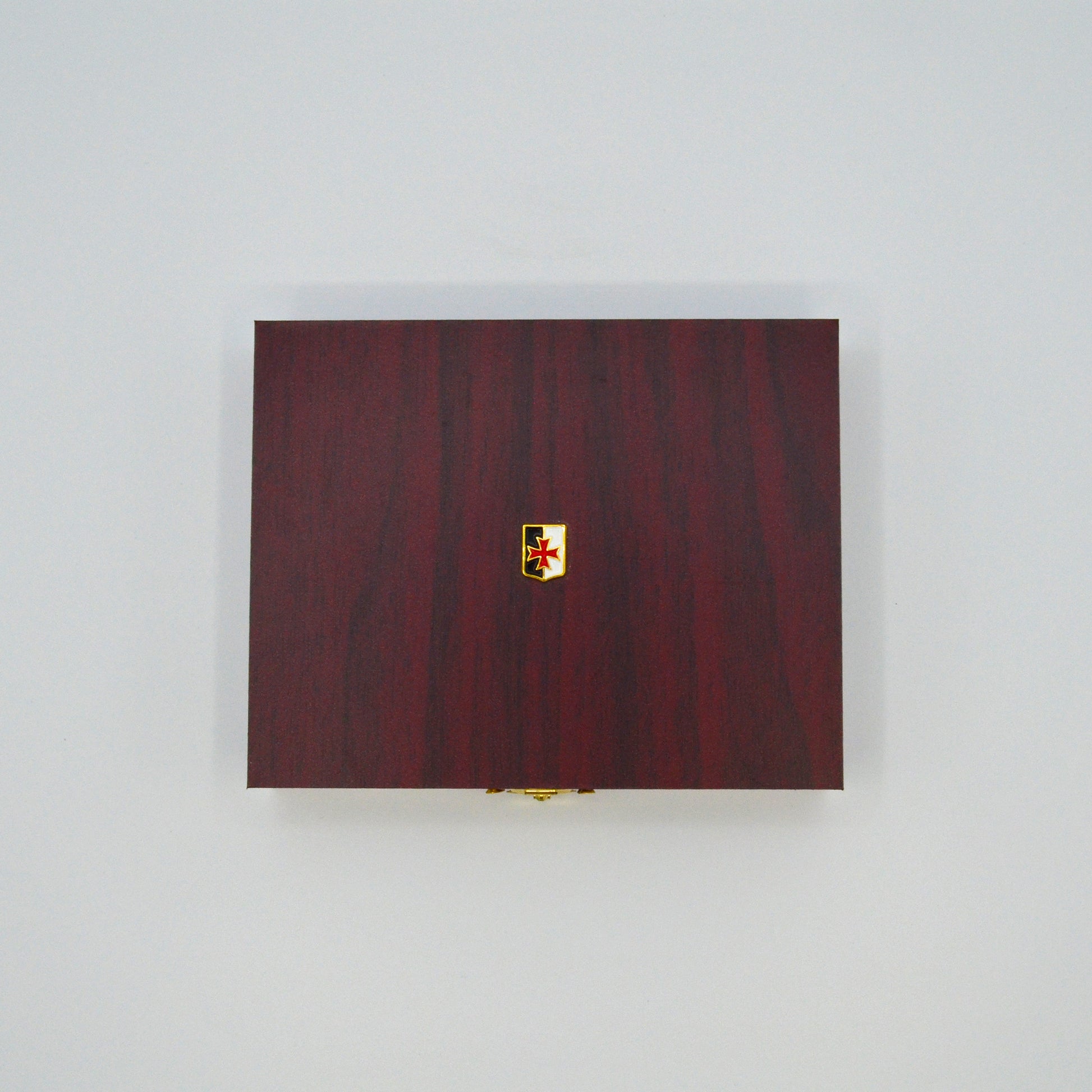 dunkle Geschenkbox in Holzoptik, goldener Verschlussknopf, oben auf Deckel kleine Templer- Fahne
