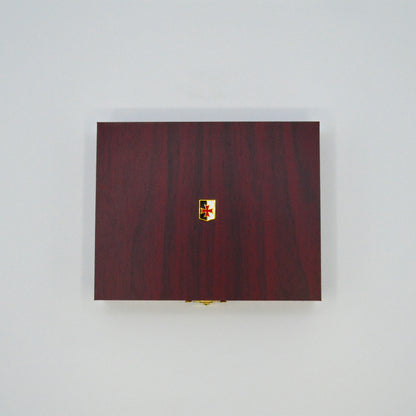 dunkle Geschenkbox in Holzoptik, goldener Verschlussknopf, oben auf Deckel kleine Templer- Fahne