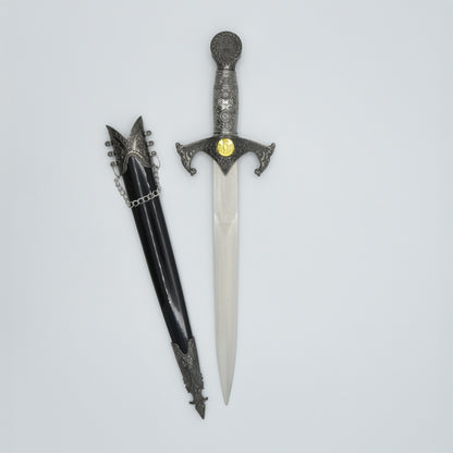 verzierter Dolch mit Kreuzrittersymbolik, daneben zugehörige Scheide in schwarz mit Verzierungen und Kettchen am Schaft, ungeschliffene Klinge ist sichtbar